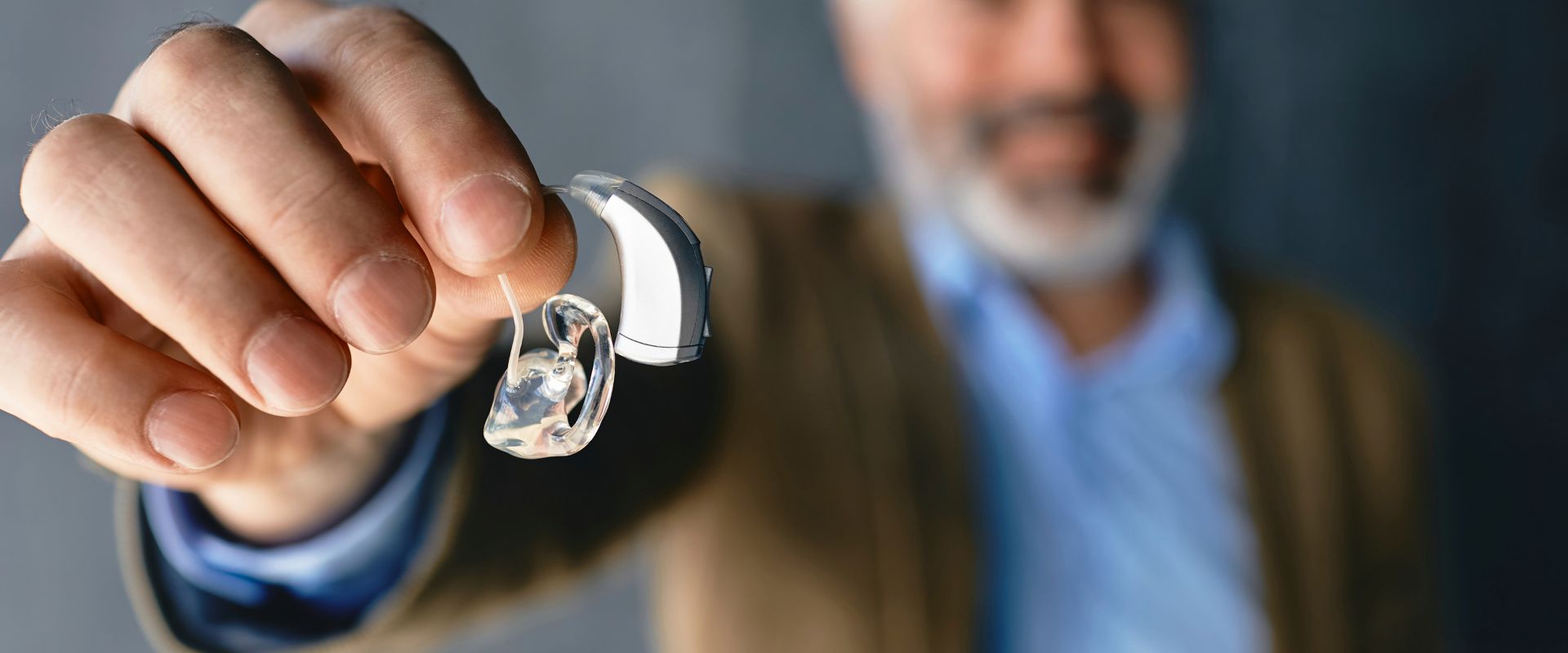 man holding clean hearing aids